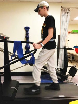 a teenage boy walking on a treadmill