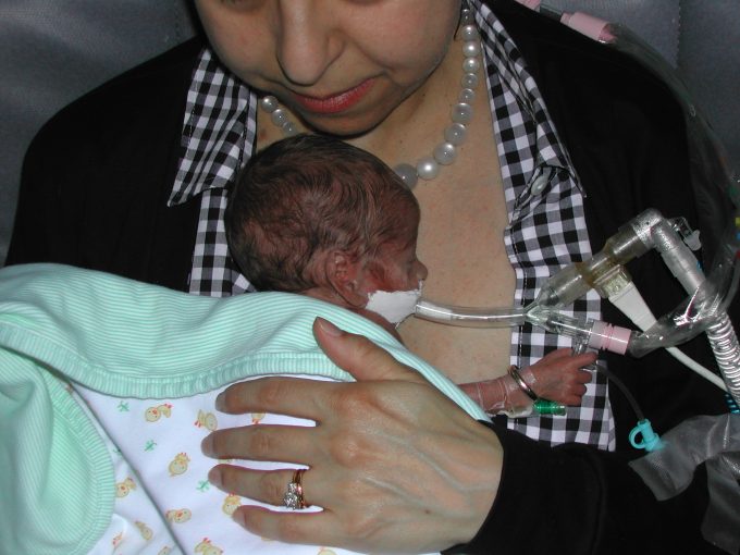 a mother holding a premature baby against her skin