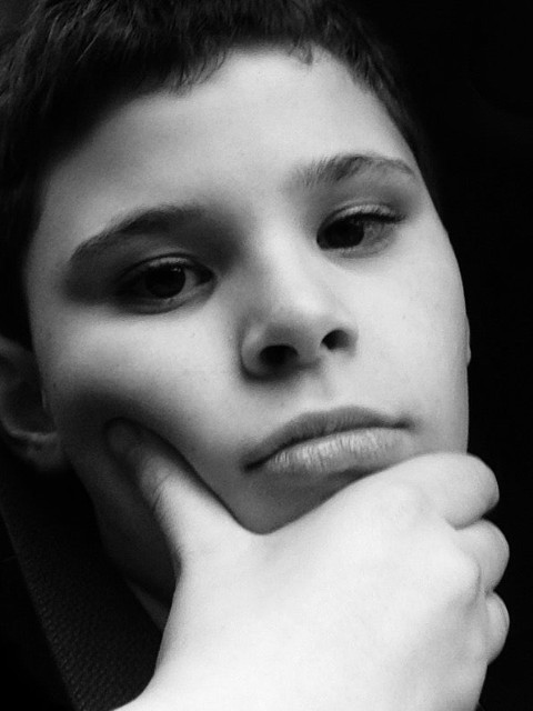 an artistic black and white photo of a young teen boy