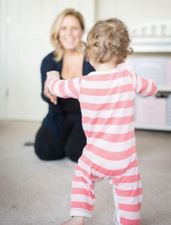 a young girl walking toward a woman
