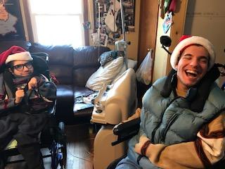 two boys in wheelchairs and santa hats