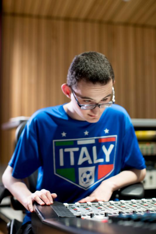 a teenage boy working the levels at a music studio