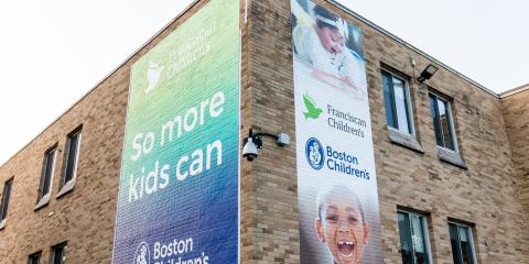 a brick building with two posters with boston childrens and franciscan childrens